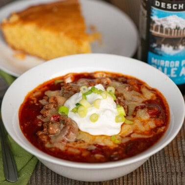 beer chili topped with cheese, sour cream, and green onions.