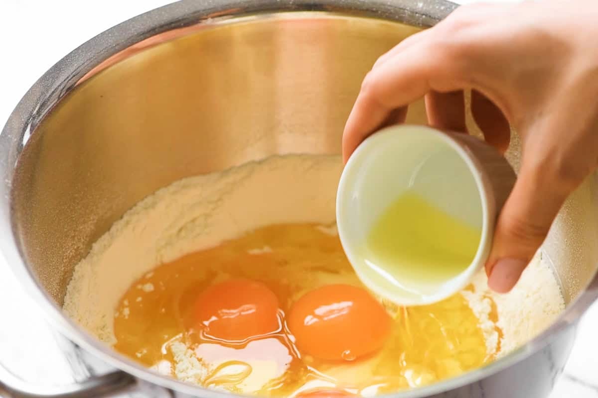 adding ingredients to bowl to make homemade challah bread.