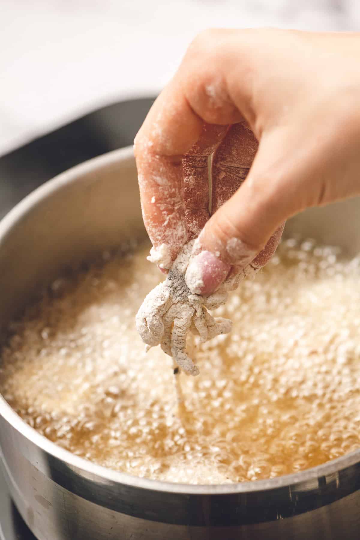 dropping calamari into hot oil.