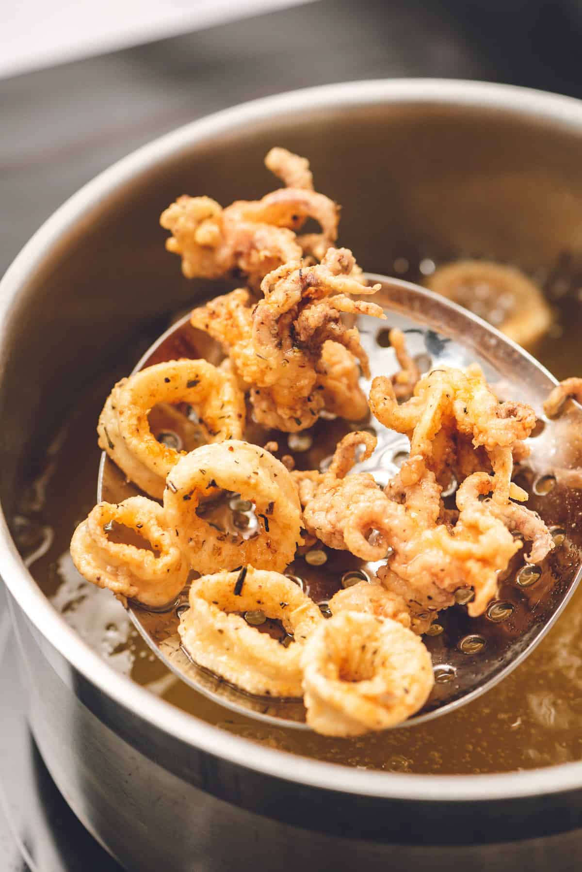 lifting fried calamari out of oil.