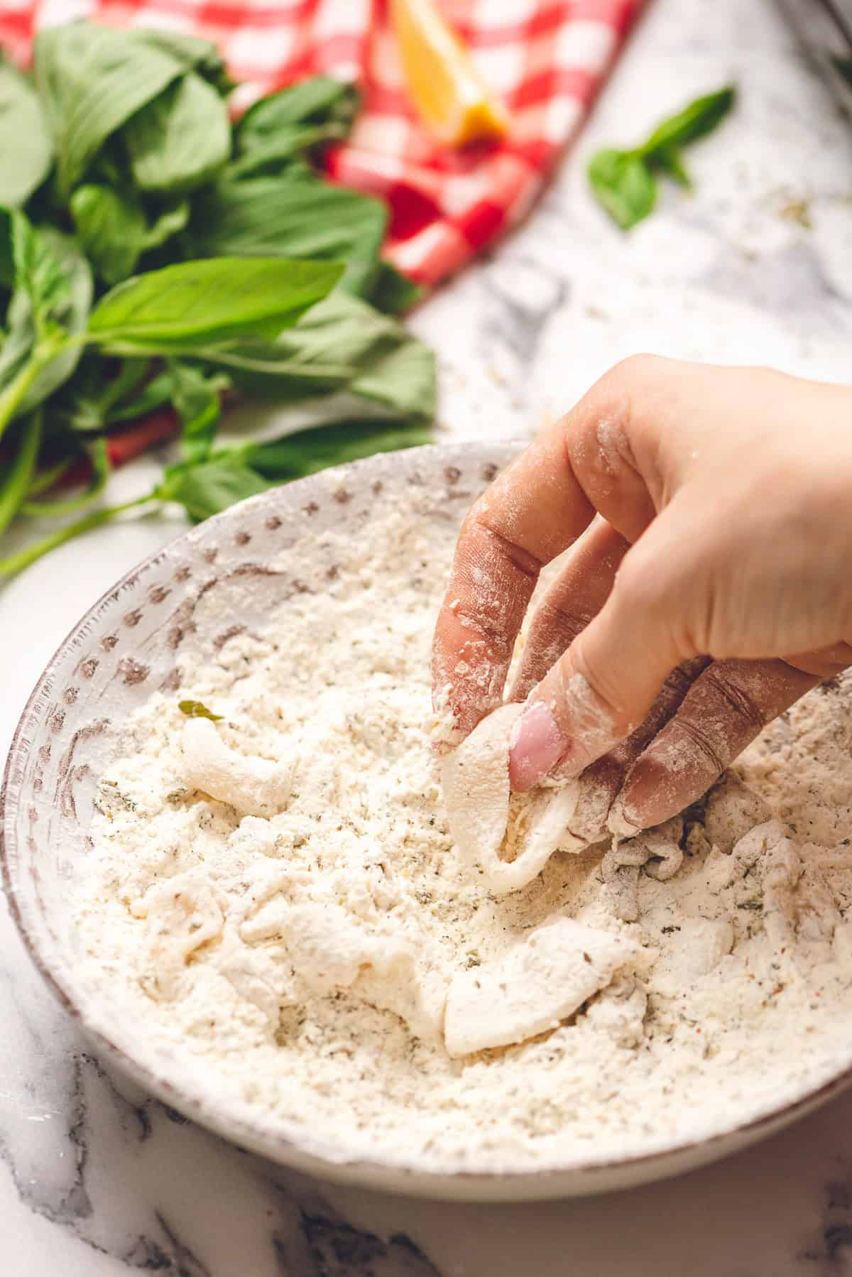 coating calamari in flour mixture.