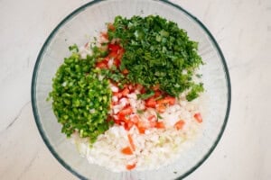 chopped ingredients for homemade pico de gallo in glass bowl.