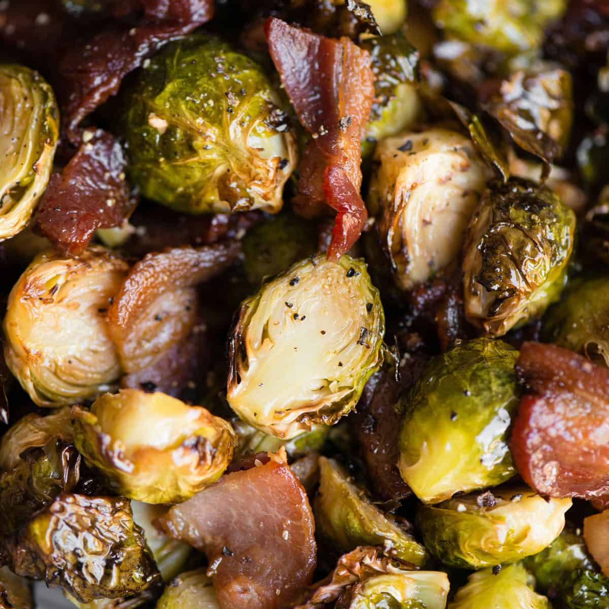 Golden brown air fryer Brussels sprouts with crispy bacon in a white dish