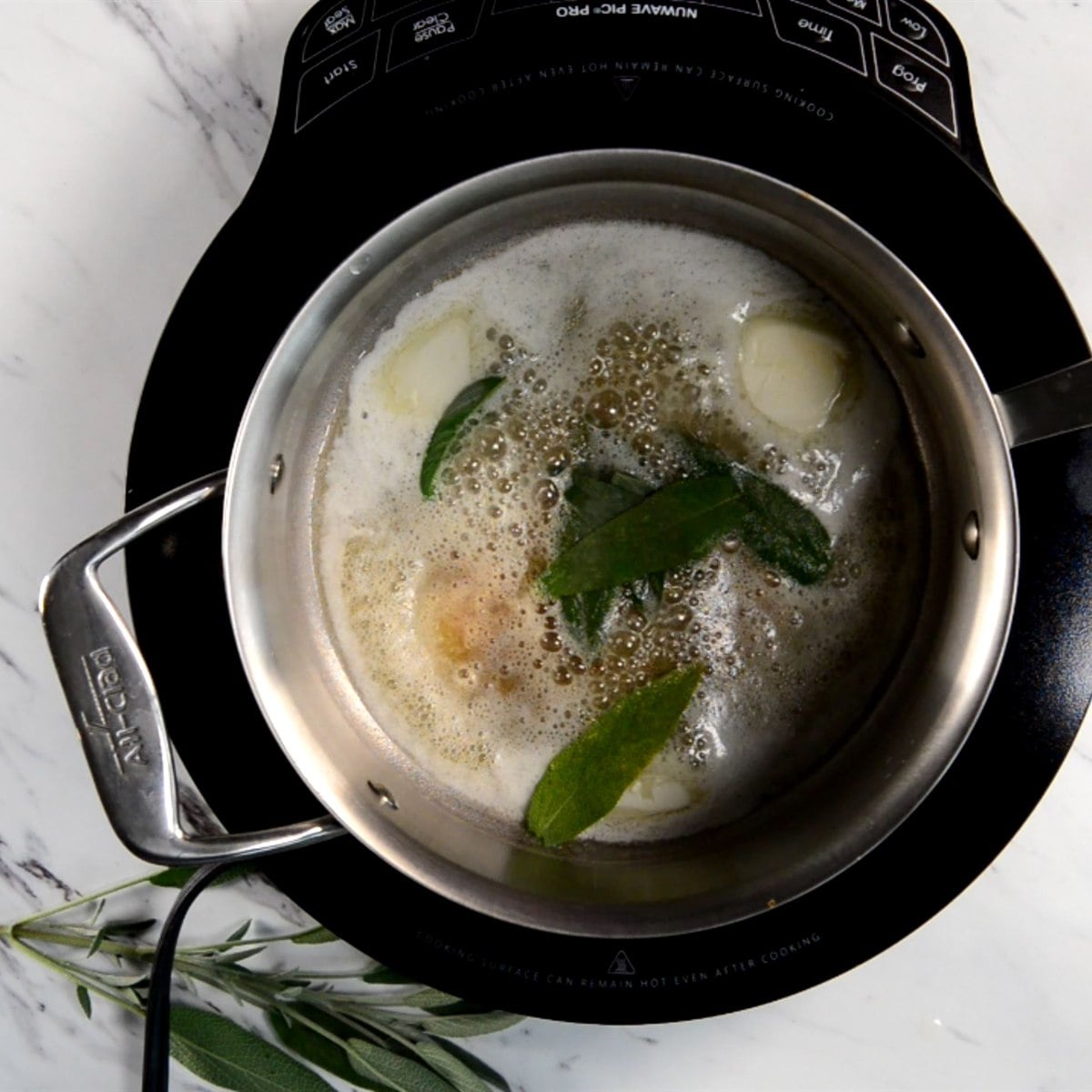 butter and fresh sage leaves cooking in a saucepan for brown butter sage sauce