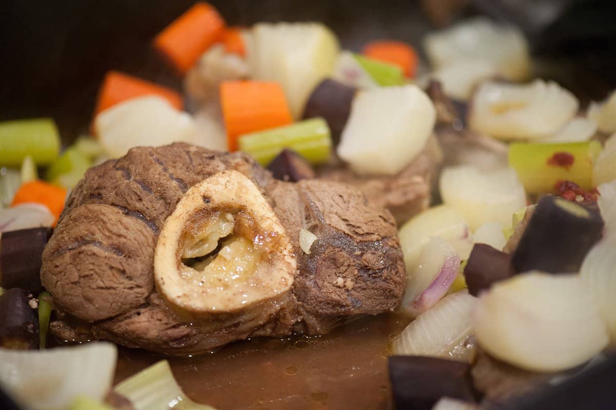 a roasted beef bone with marrow, onions, carrots and celery in the stockpot.