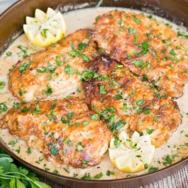 four breaded chicken breasts in cream sauce