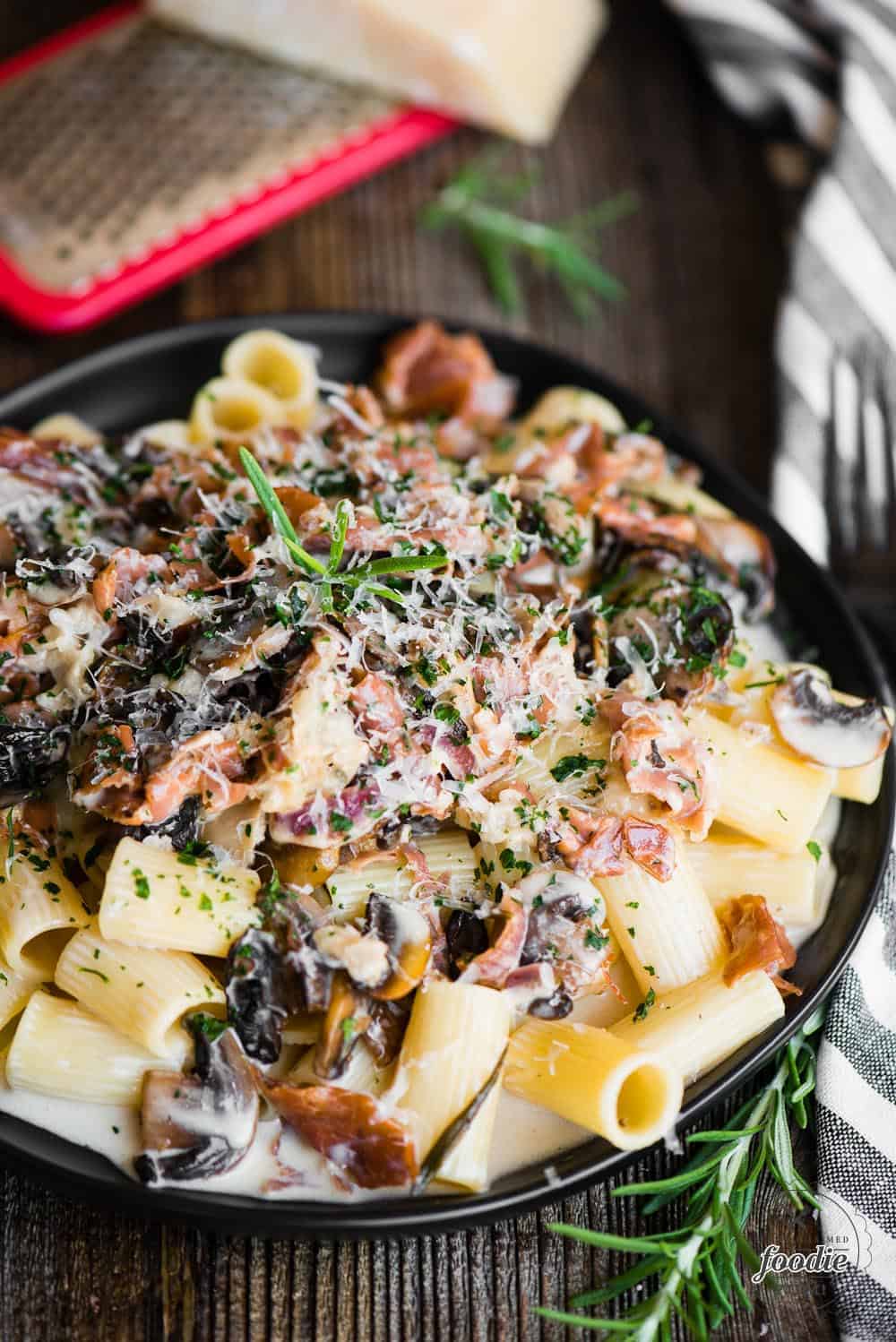 bowl of creamy rigatoni pasta with mushrooms and prosciutto