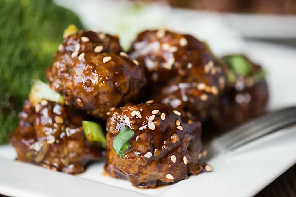 teriyaki meatballs on plate with sesame seeds