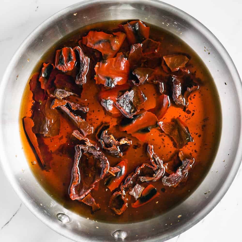 browned red chiles soaking in boiling water