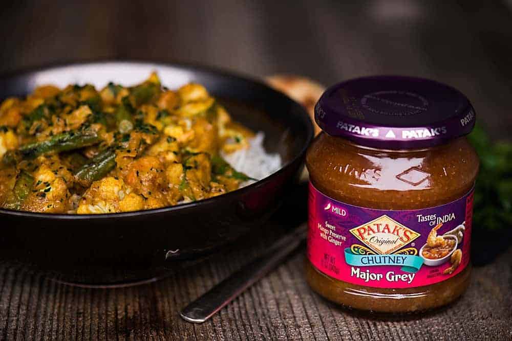 a bowl of vegetable korma, with sauce on the side