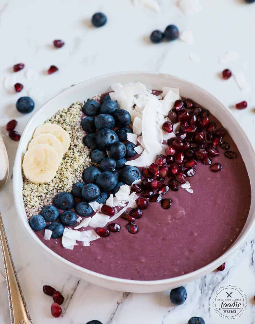 acai bowl with blueberry, pomegranate, coconut, hemp seed toppings