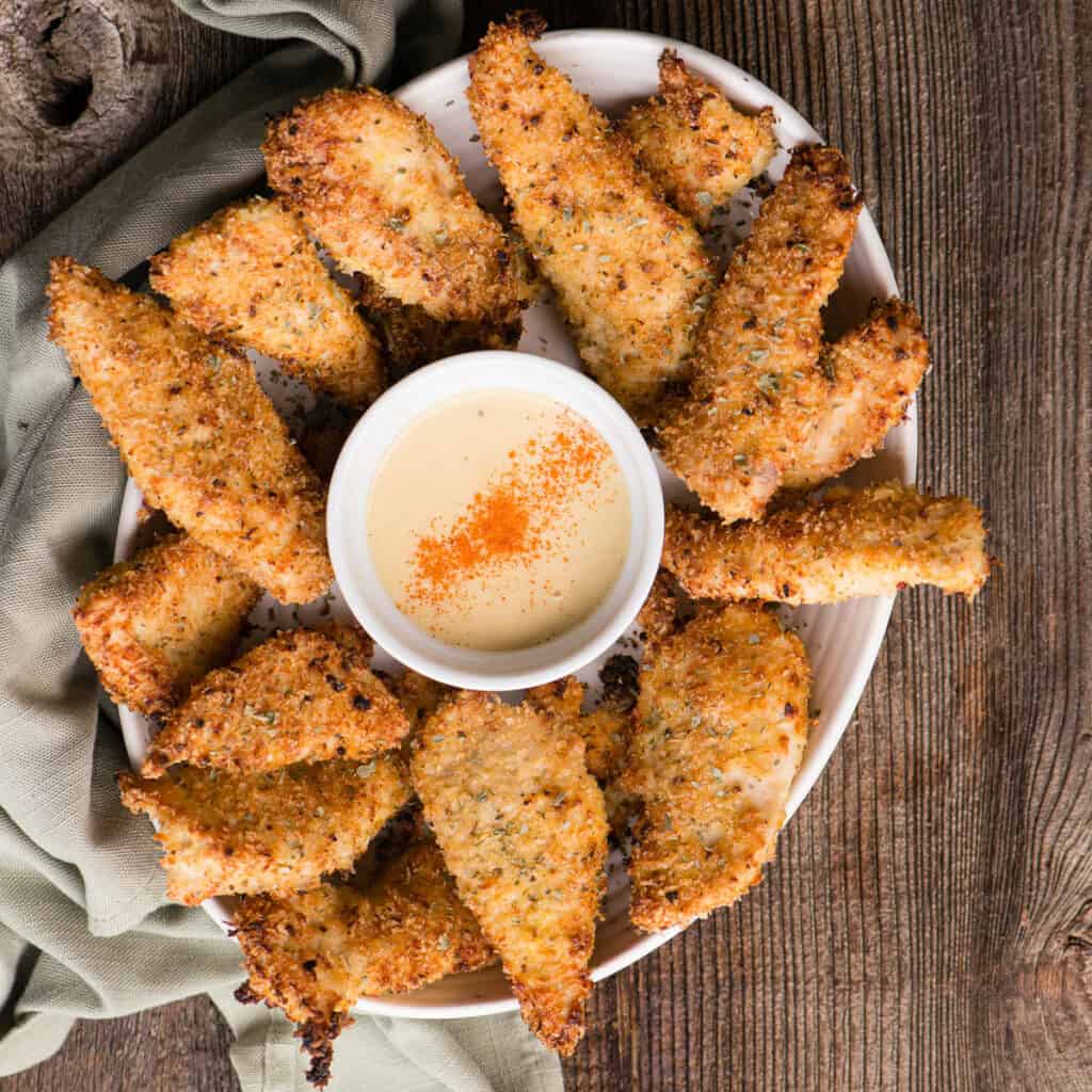 platter of homemade chicken tenders with sauce