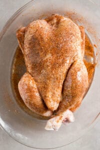 dry rubbed whole chicken covered in olive oil spray