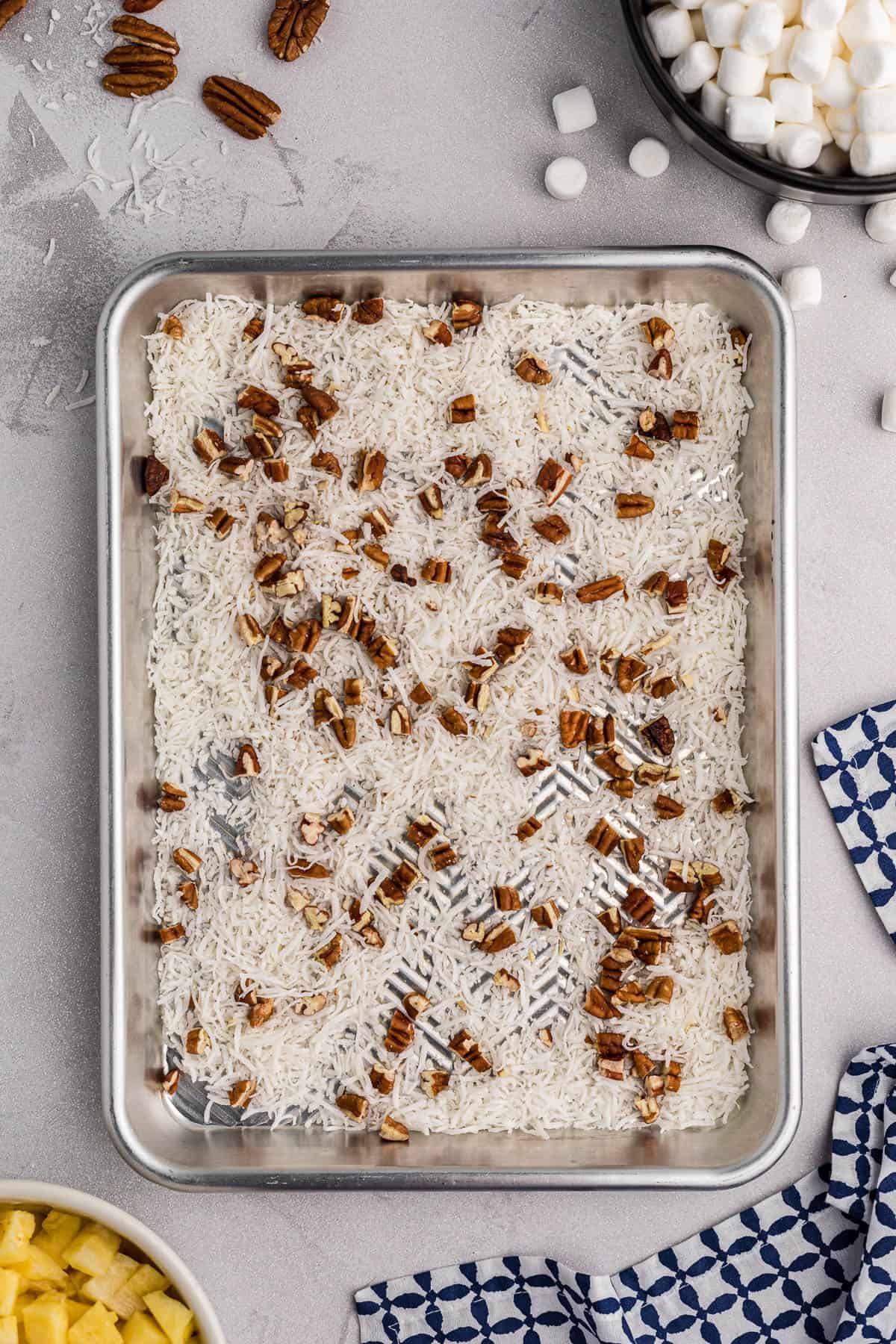 raw pecans and shredded coconut on baking sheet.
