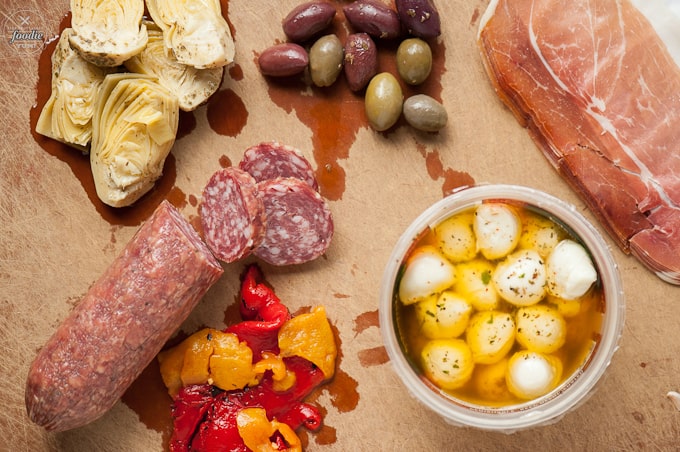 salami, roasted peppers, artichoke hearts olives, cheese on cutting board