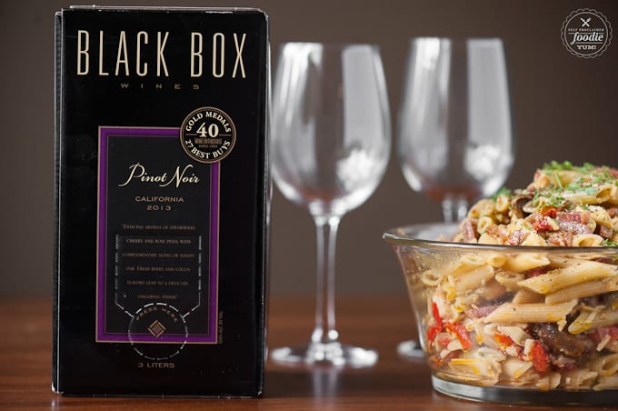 box of wine with glasses and pasta salad