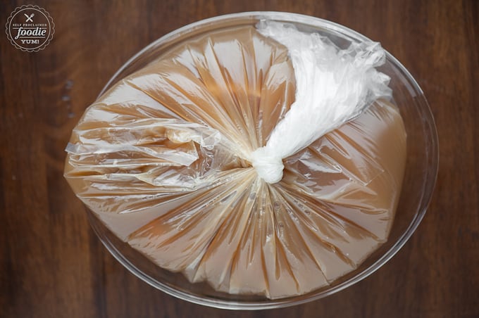 plastic bag with pork roast in apple cider brine