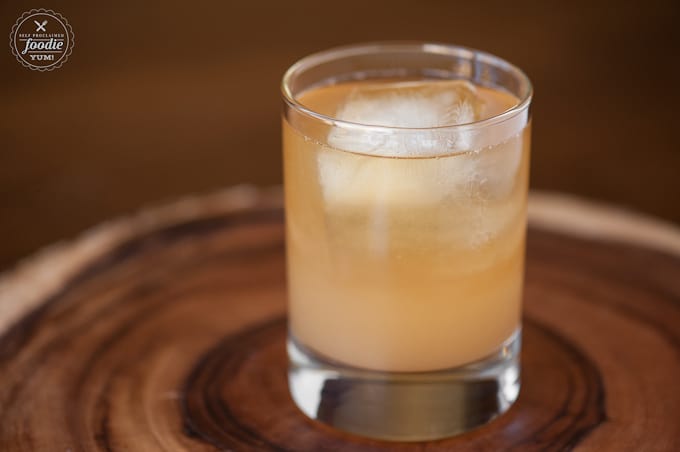 apple ginger whiskey cocktail in glass with ice