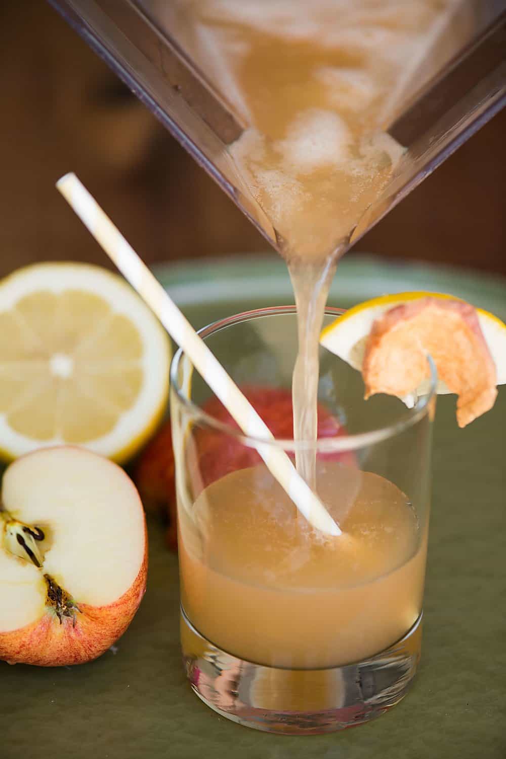 a blender pouring apple whiskey sour into a glass