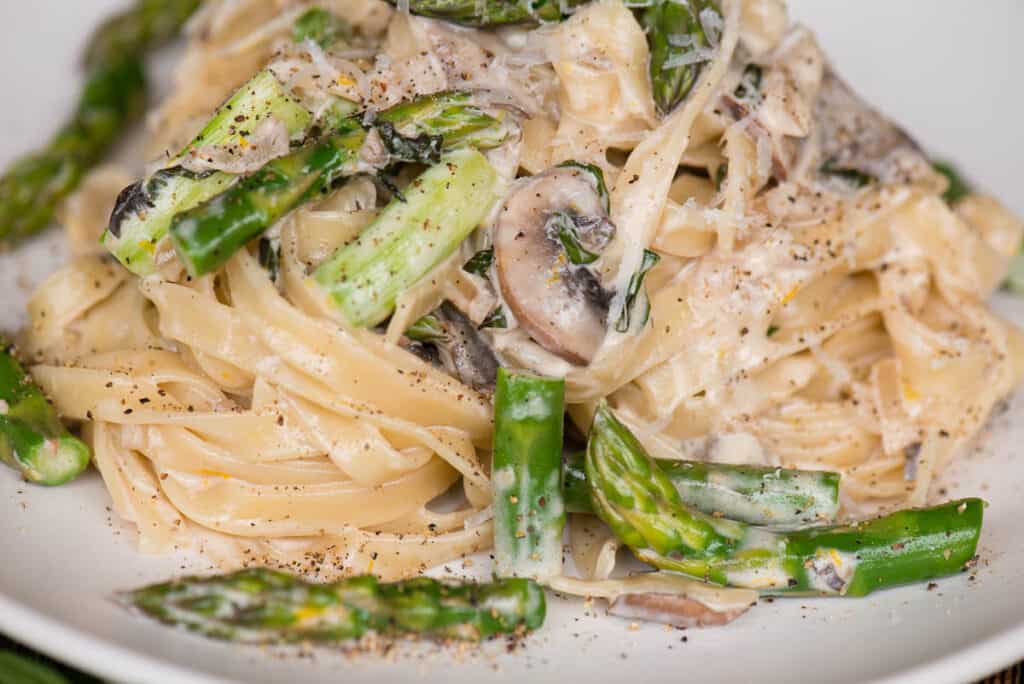 close up of Fettuccine Alfredo with asparagus and mushrooms