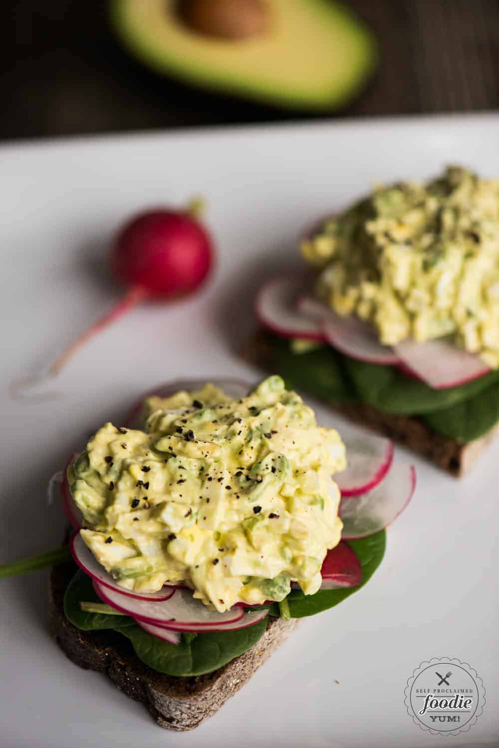 egg salad with avocados on toast with radish and spinach