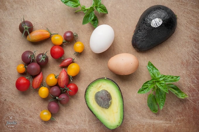 Food on the cutting board, with Avocado, tomatoes, and Egg