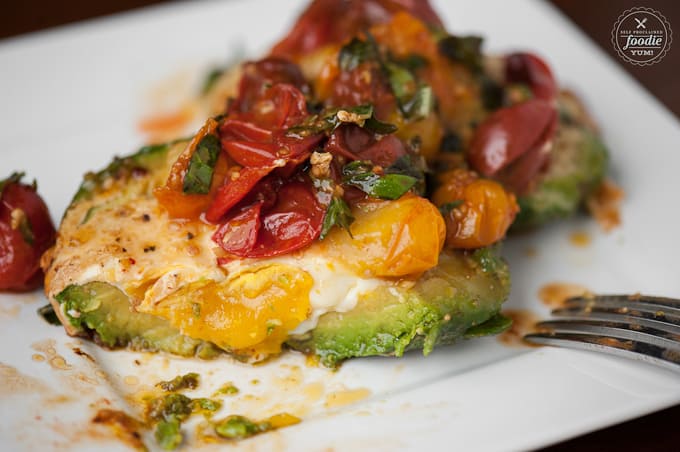 a close up of tomatoes and egg cooked in avocado