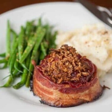 Bacon Wrapped mini Meatloaf is the best comfort food you can make for dinner. Grass fed ground beef, bacon, and more served as individual portion sizes.
