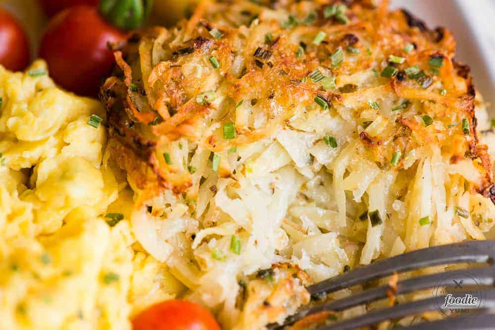 bite of homemade baked parmesan hashbrowns made with fresh potato