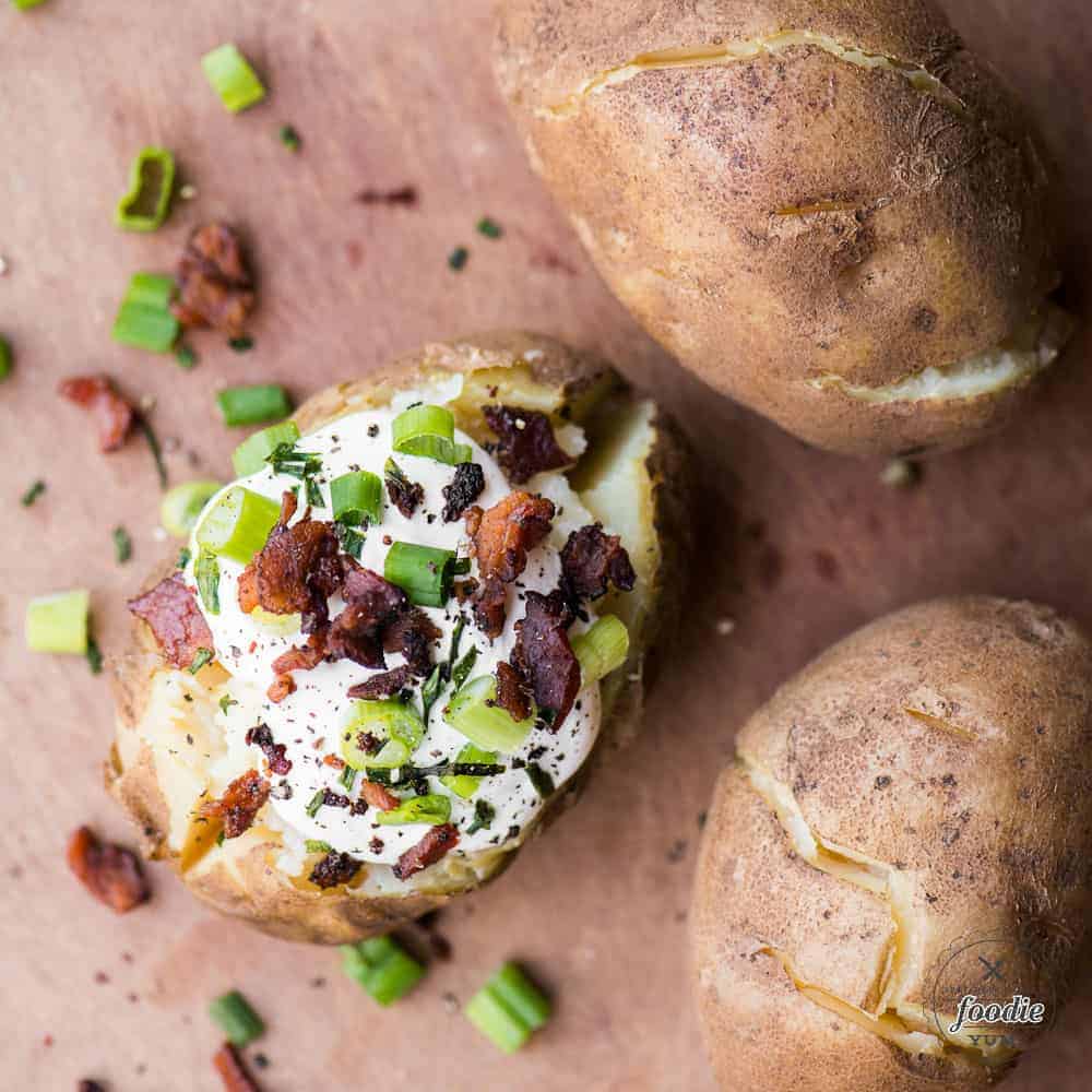 Quick and easy baked potatoes made in the Instant Pot topped with sour cream and bacon