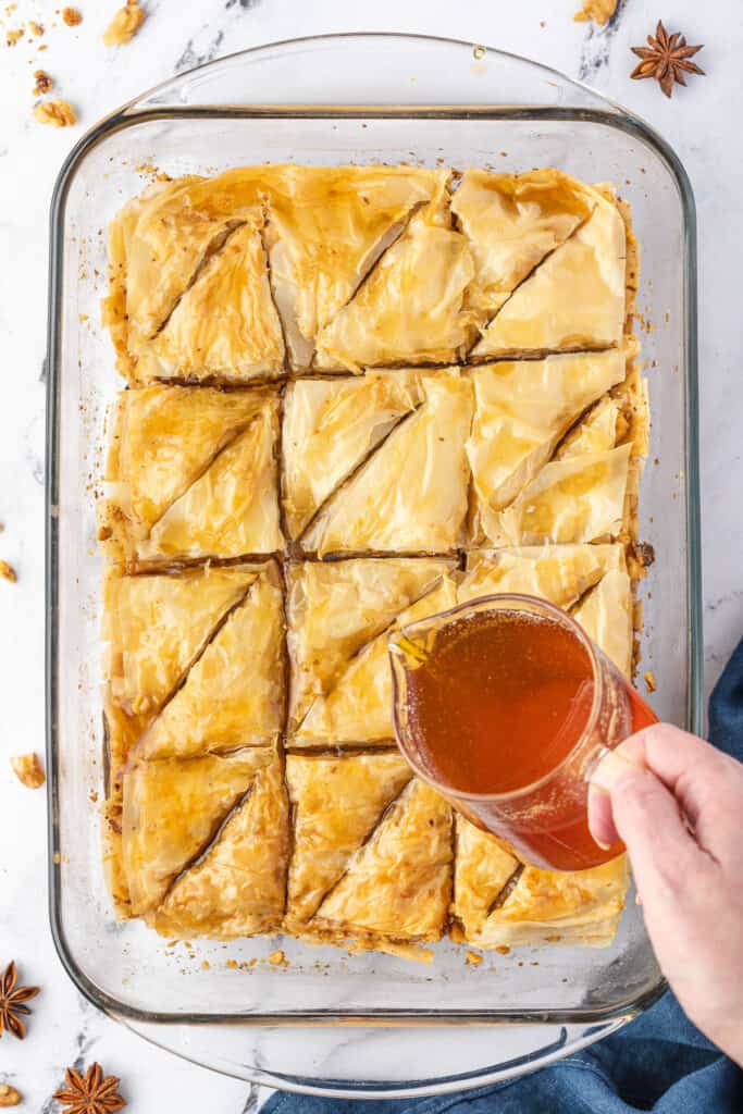 pouring honey syrup on Baklava