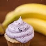 a cupcake with blueberry frosting with bananas