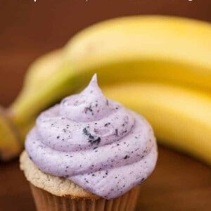 a cupcake with blueberry frosting with bananas