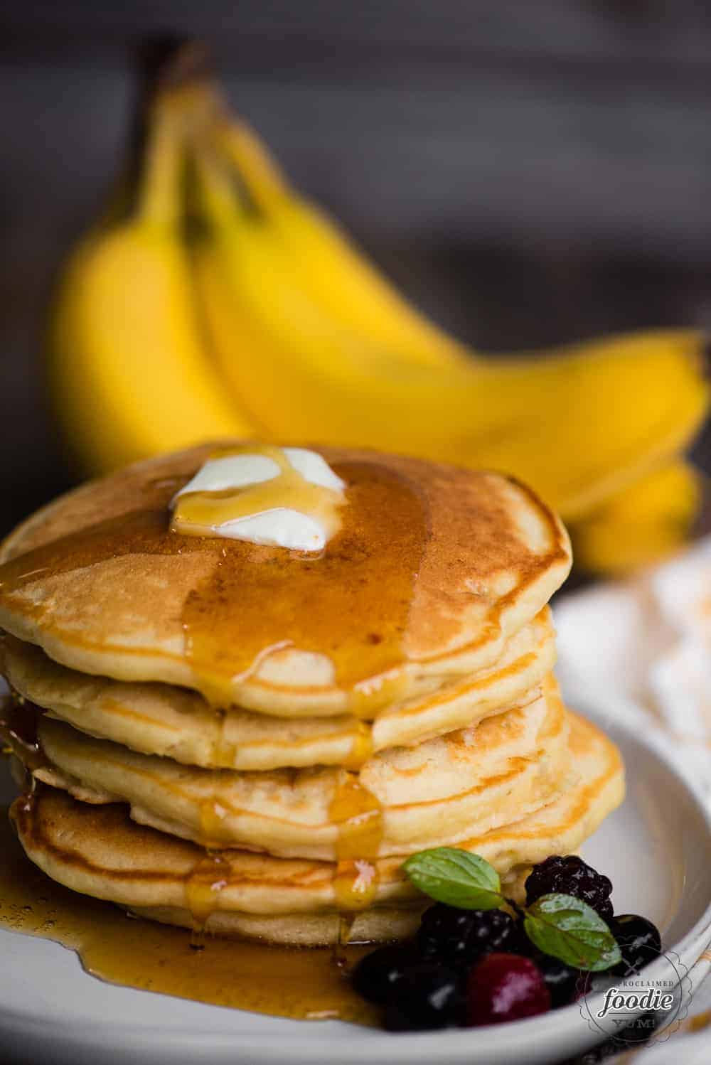 banana pancakes on plate with butter and syrup