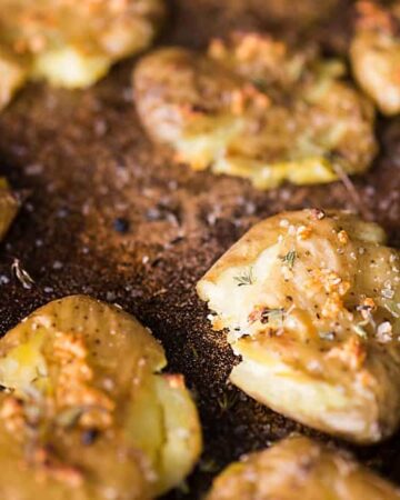 Bite Sized Smashed Potatoes are an easy side dish. Baby potatoes baked with fresh thyme, garlic, and olive oil are crispy on the outside and soft inside.