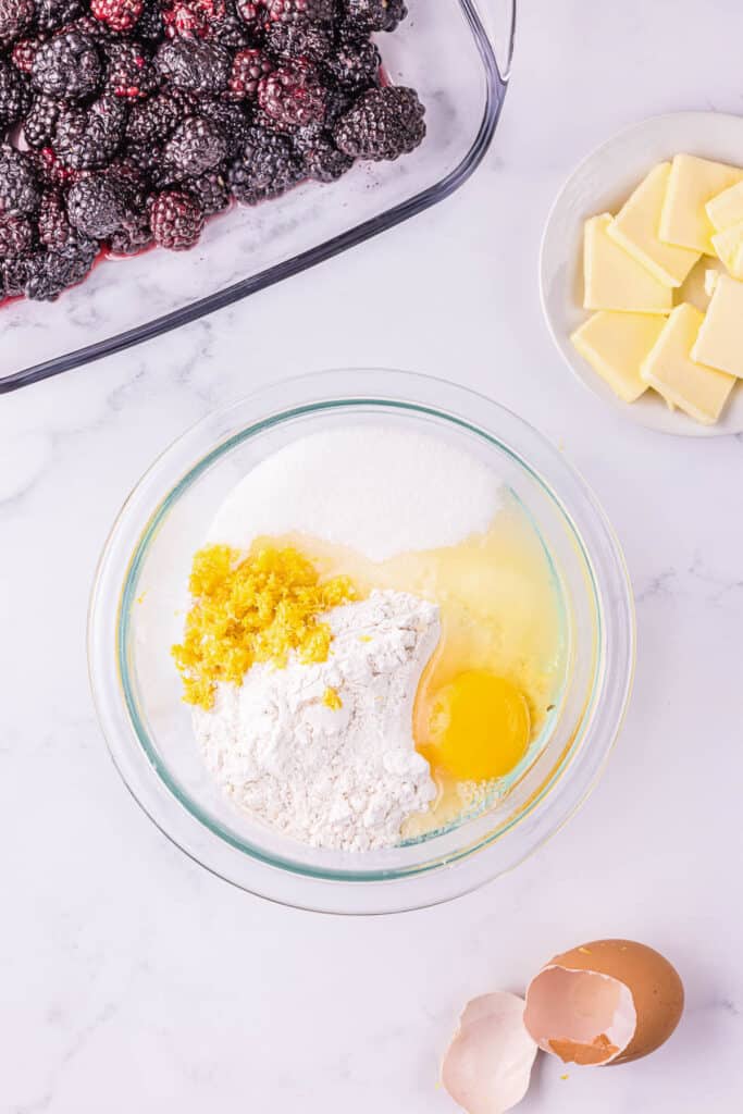 mixing topping ingredients for blackberry cobbler recipe.