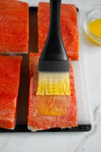 brushing salmon filets with melted butter.