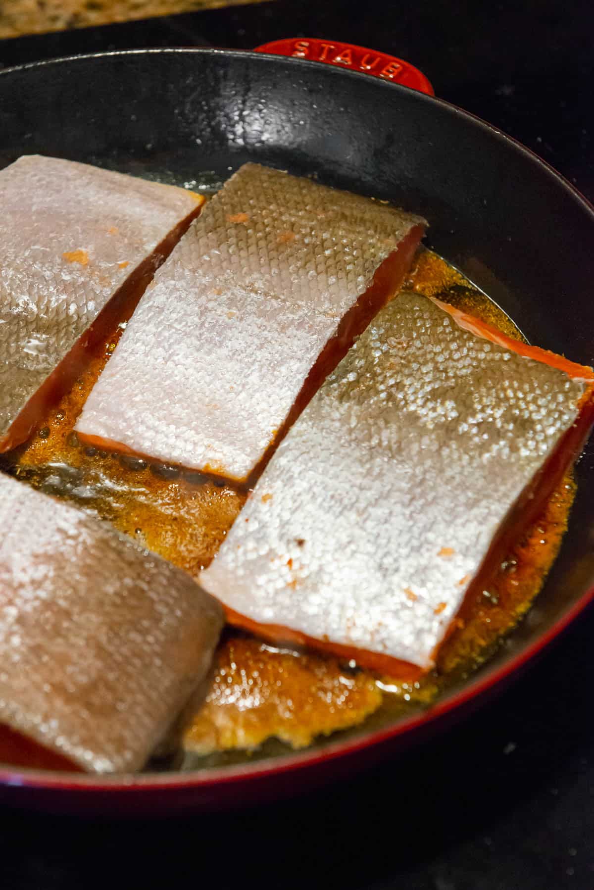 searing Cajun seasoned salmon filets with skin side up.