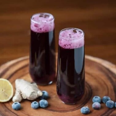 This gorgeous Blueberry Ginger Bellini uses blueberries & blueberry juice paired with fresh ginger to make a refreshing non-alcoholic or boozy cocktail.