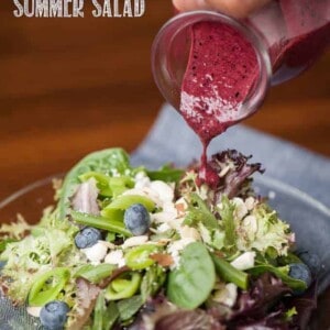 summer salad with blueberry vinaigrette being poured