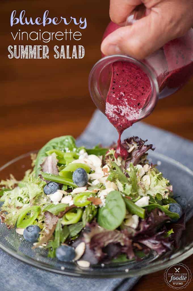 summer salad with blueberry vinaigrette being poured