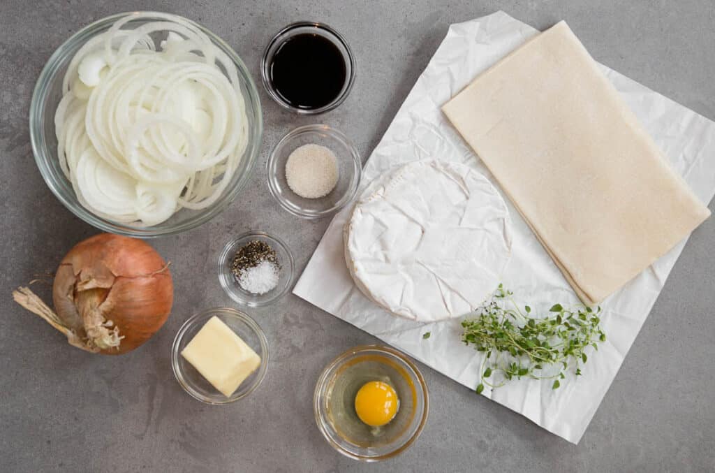 ingredients needed to bake brie wrapped in puff pastry with caramelized onions