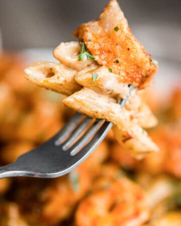 close up of fork with cajun shrimp pasta in cream sauce