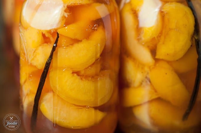 a close up of canned peaches with vanilla bean