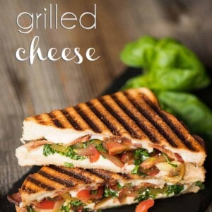 two caprese grilled cheese half sandwiches stacked on top of each other