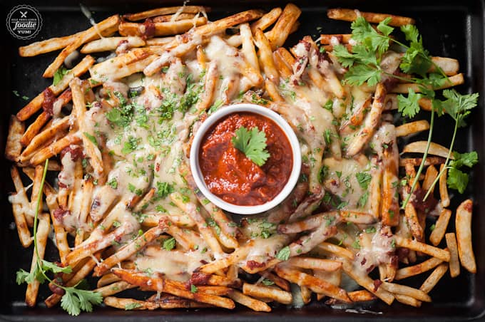 baking sheet with cheese fries and chipotle sauce