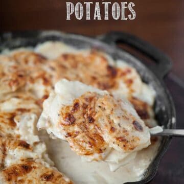 scooping a serving of homemade scalloped potatoes out of cast iron pan