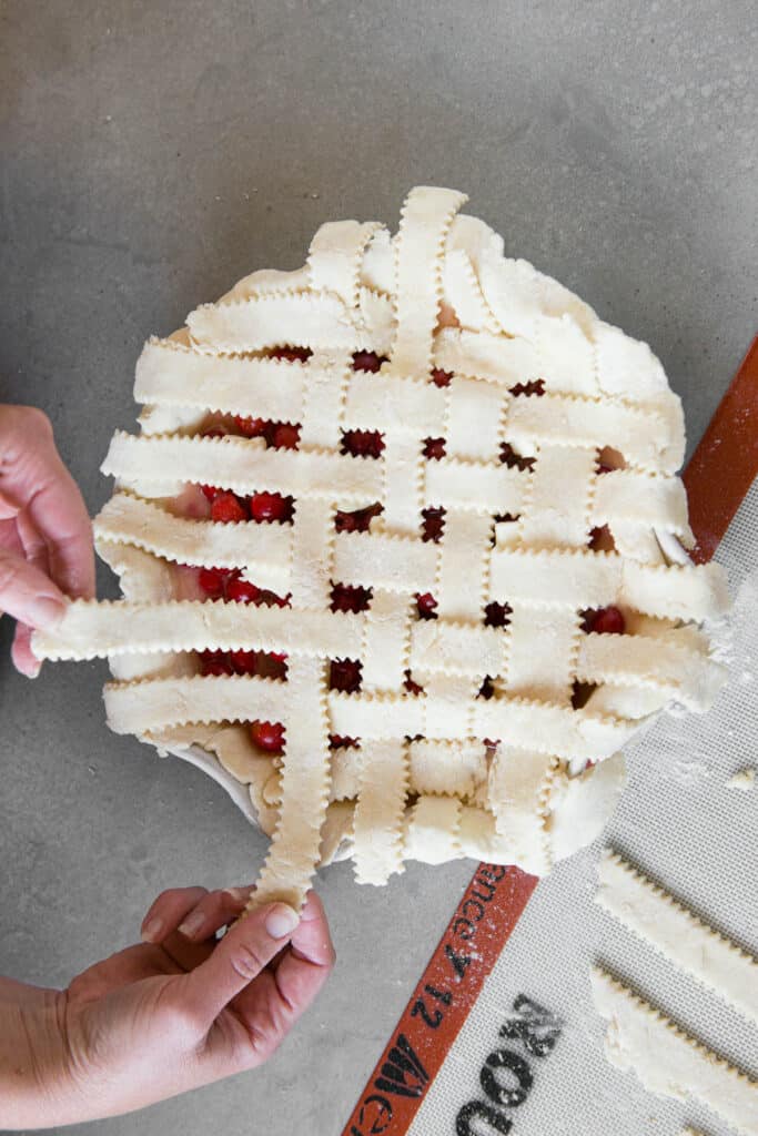 hands showing how to make pie crust lattice weave