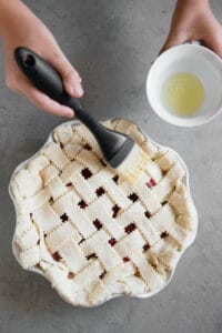 pastry brush applying egg white to fruit pie