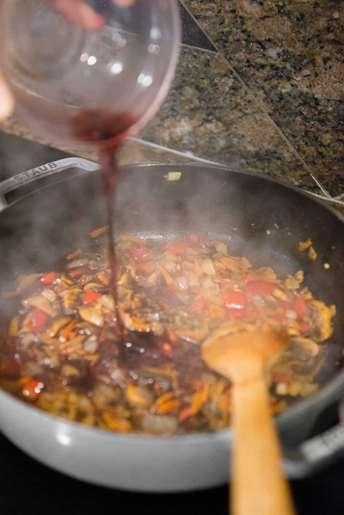 pouring red wine over vegetables